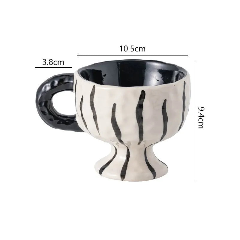 Hand-pinched irregular shaped solid colour ceramic mug on a table, showing its unique form and modern simplicity design.