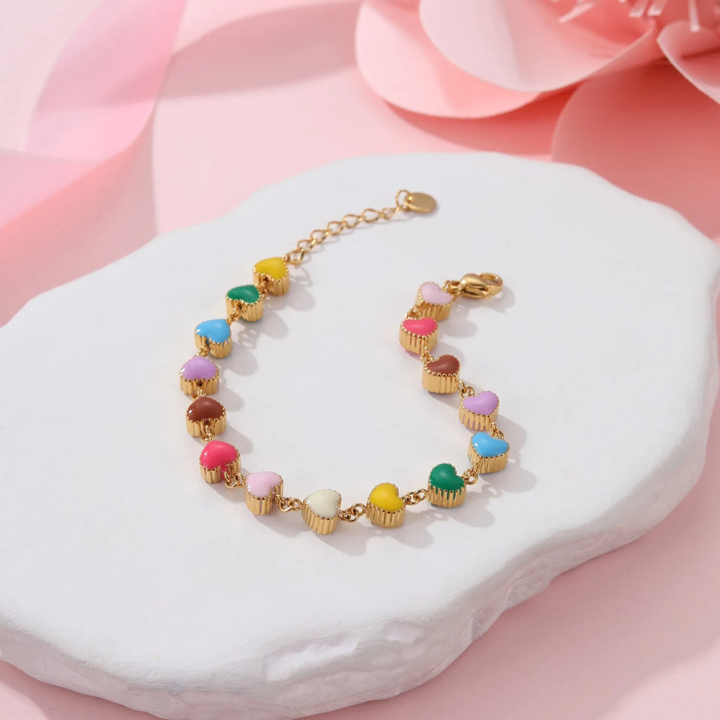 Close-up of a women's stainless steel bracelet with a colourful, heart-shaped titanium steel pendant.