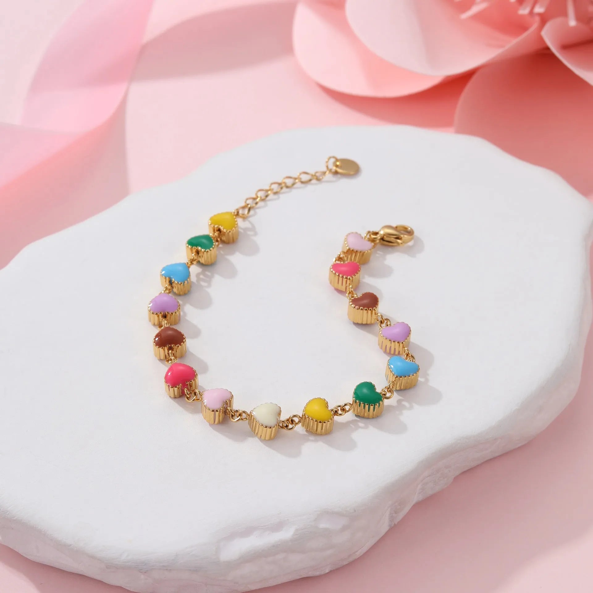 Close-up of a women's stainless steel bracelet with a colourful, heart-shaped titanium steel pendant.