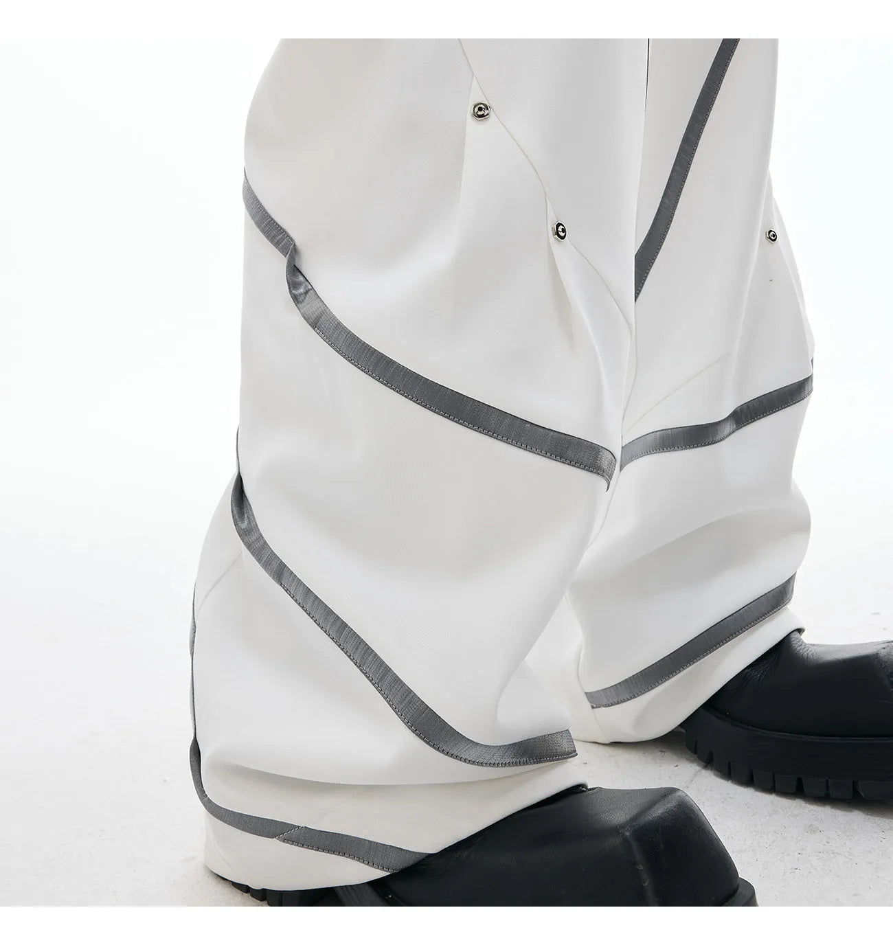 Men's polyester trousers with metal striped rivets and pleated detailing in black or white options