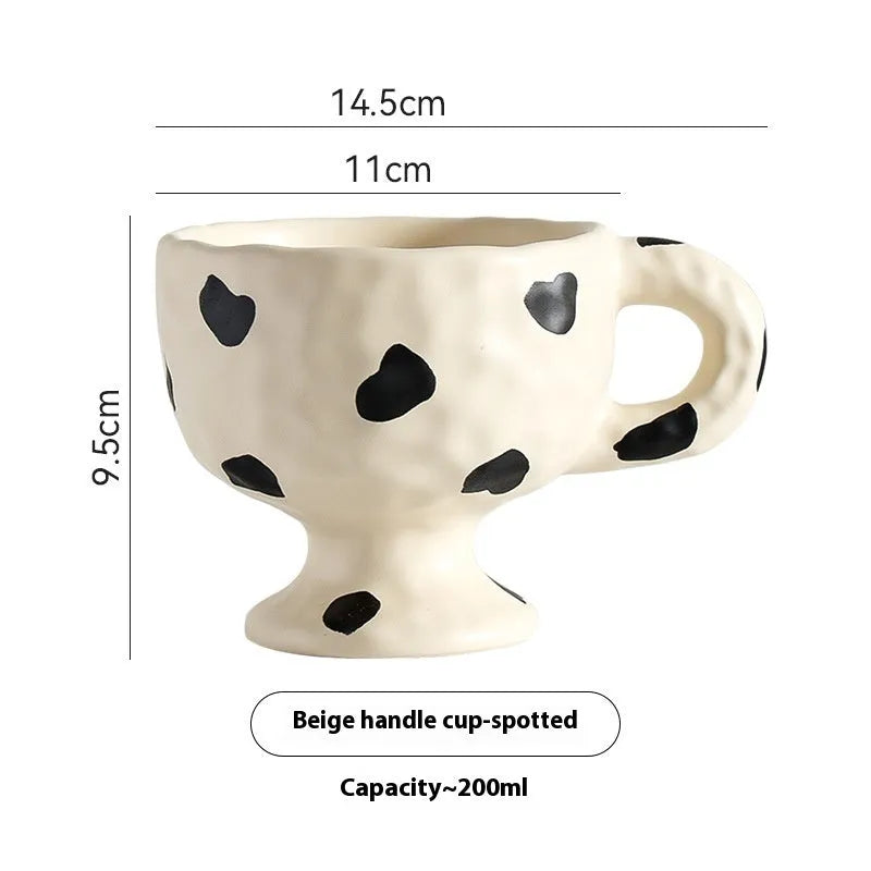 Hand-pinched irregular shaped solid colour ceramic mug on a table, showing its unique form and modern simplicity design.