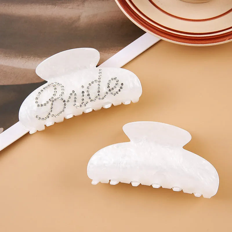 Pink and white acrylic shower shark hair clips with diamond embellishments and English letter details