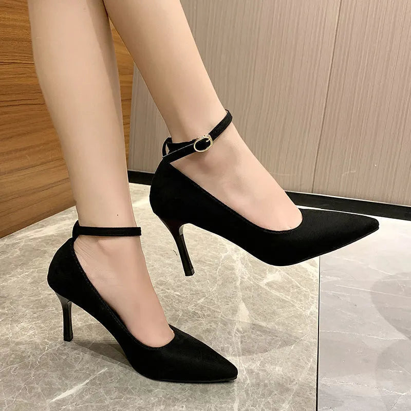 Women's black stiletto heel pump shoe with a silver buckle detail on the side.