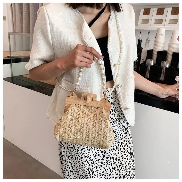 Beige straw woven women's shoulder bag with pearl chain strap showing front view