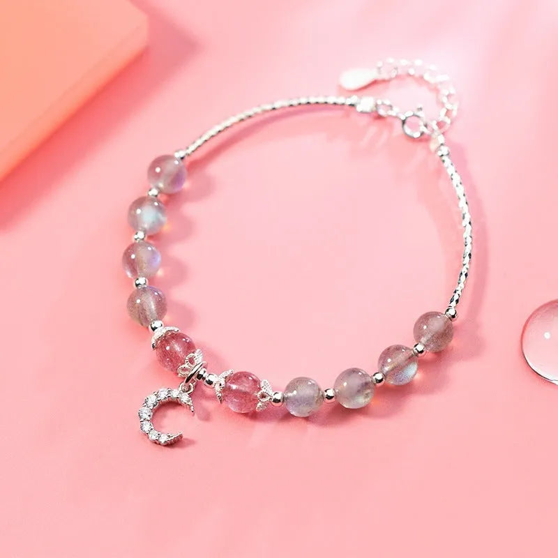 Handmade silver-toned bracelet with a blue-grey 6mm moonstone bead, small crescent moon charm, and clear crystal on an adjustable chain.