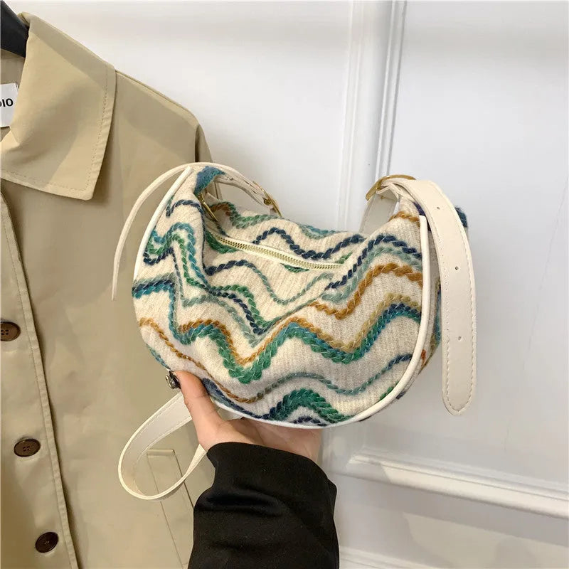 Women's woven straw crossbody bag with a single strap and internal organisation pockets.
