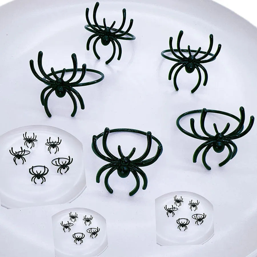 Six black alloy spider-shaped napkin rings for Halloween table decoration.