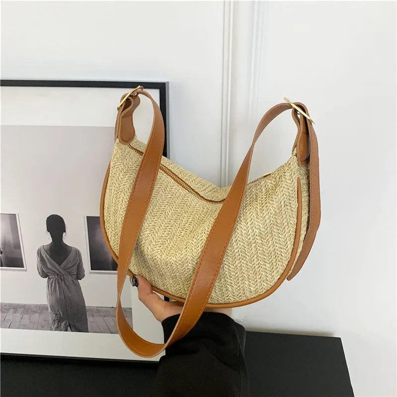 Women's woven straw crossbody bag with a single strap and internal organisation pockets.