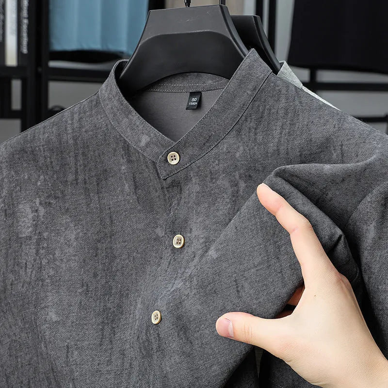 Man wearing a loose-fit black grey linen blend cardigan shirt with a stand collar.
