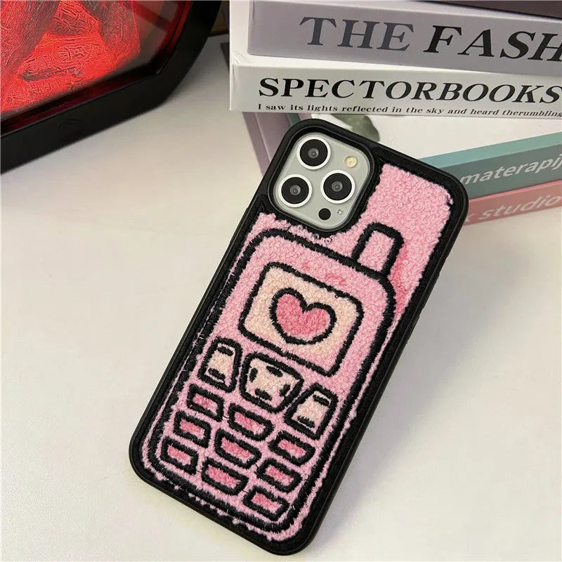 Pink towel embroidered soft TPU case for iPhone on a table.
