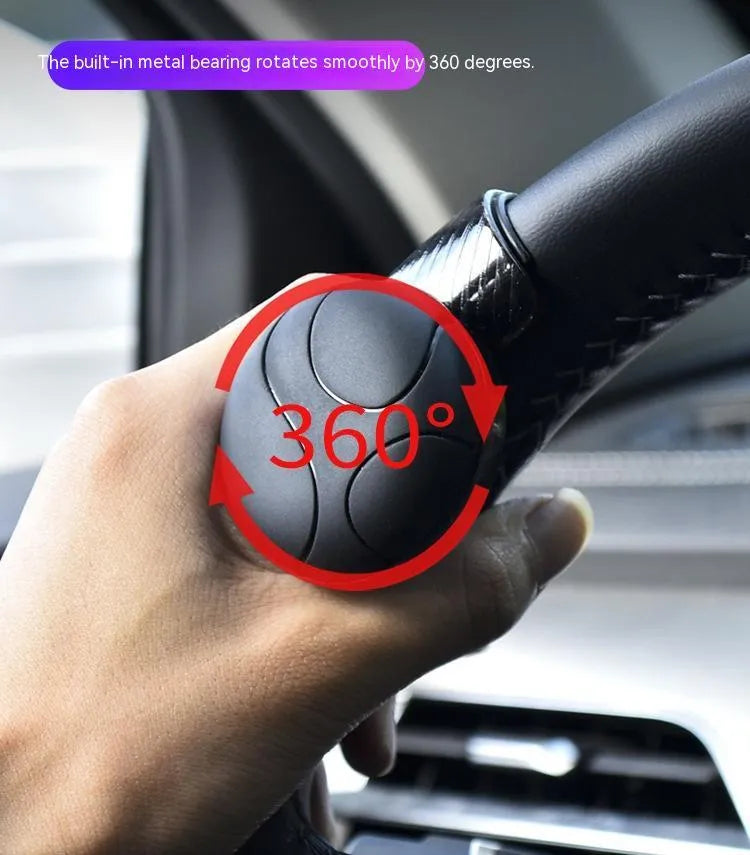 Black and blue silicone steering wheel assist ball for single-handed driving on a car steering wheel.