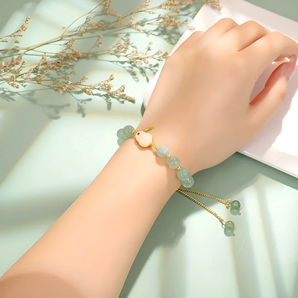 Rabbit charm bracelet with green aventurine and strawberry quartz stones on a gold plated copper chain