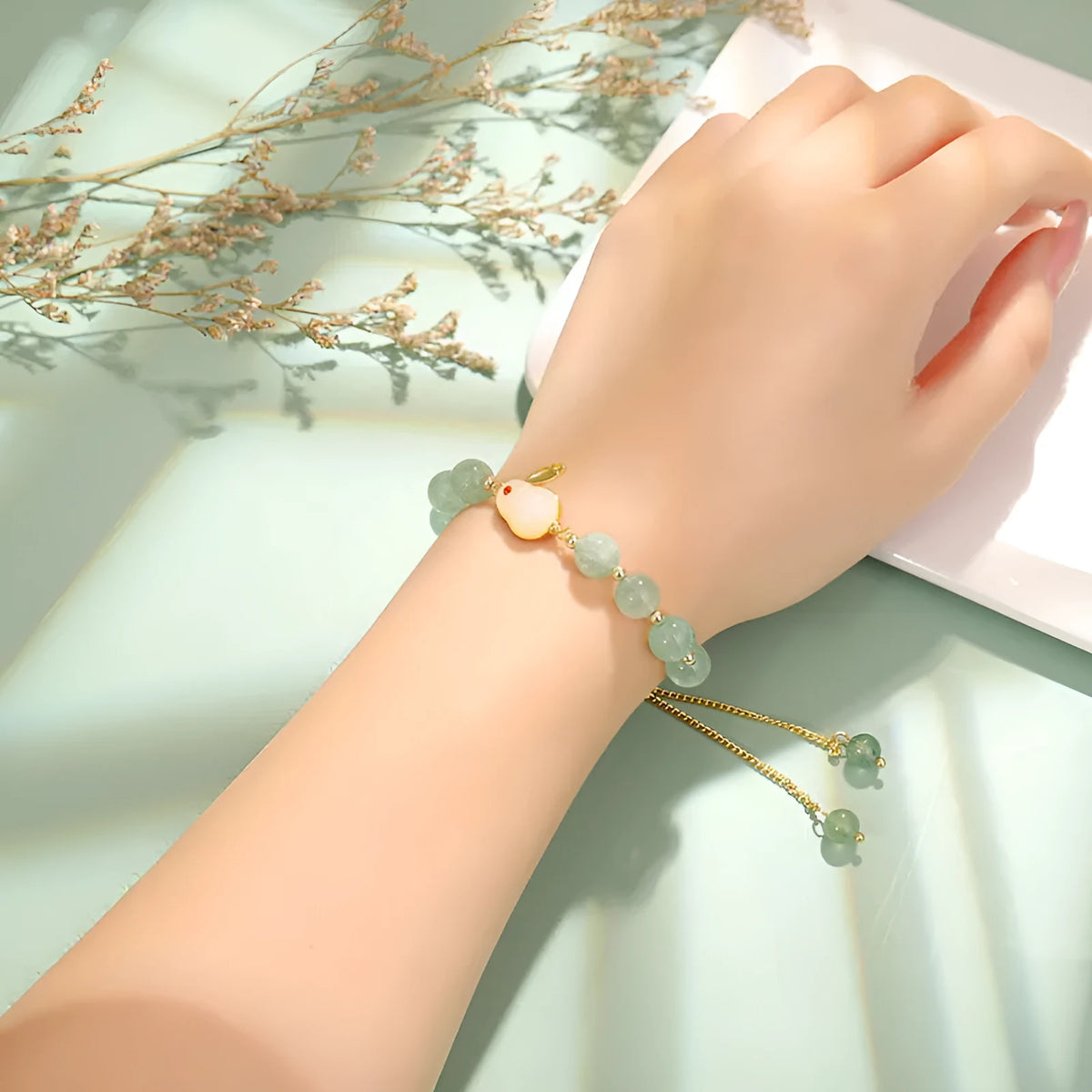 Rabbit charm bracelet with green aventurine and strawberry quartz stones on a gold plated copper chain