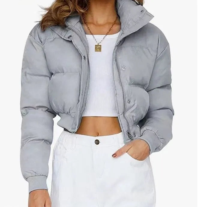 Women's loose-fit blue polyester jacket with long sleeves on a hanger.