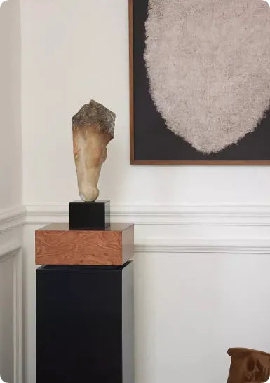A tall, abstract white horse head sculpture with a carved surface texture on a shelf.