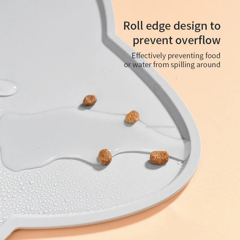 Blue silicone cat head shaped pet feeding mat placed on a wooden floor.