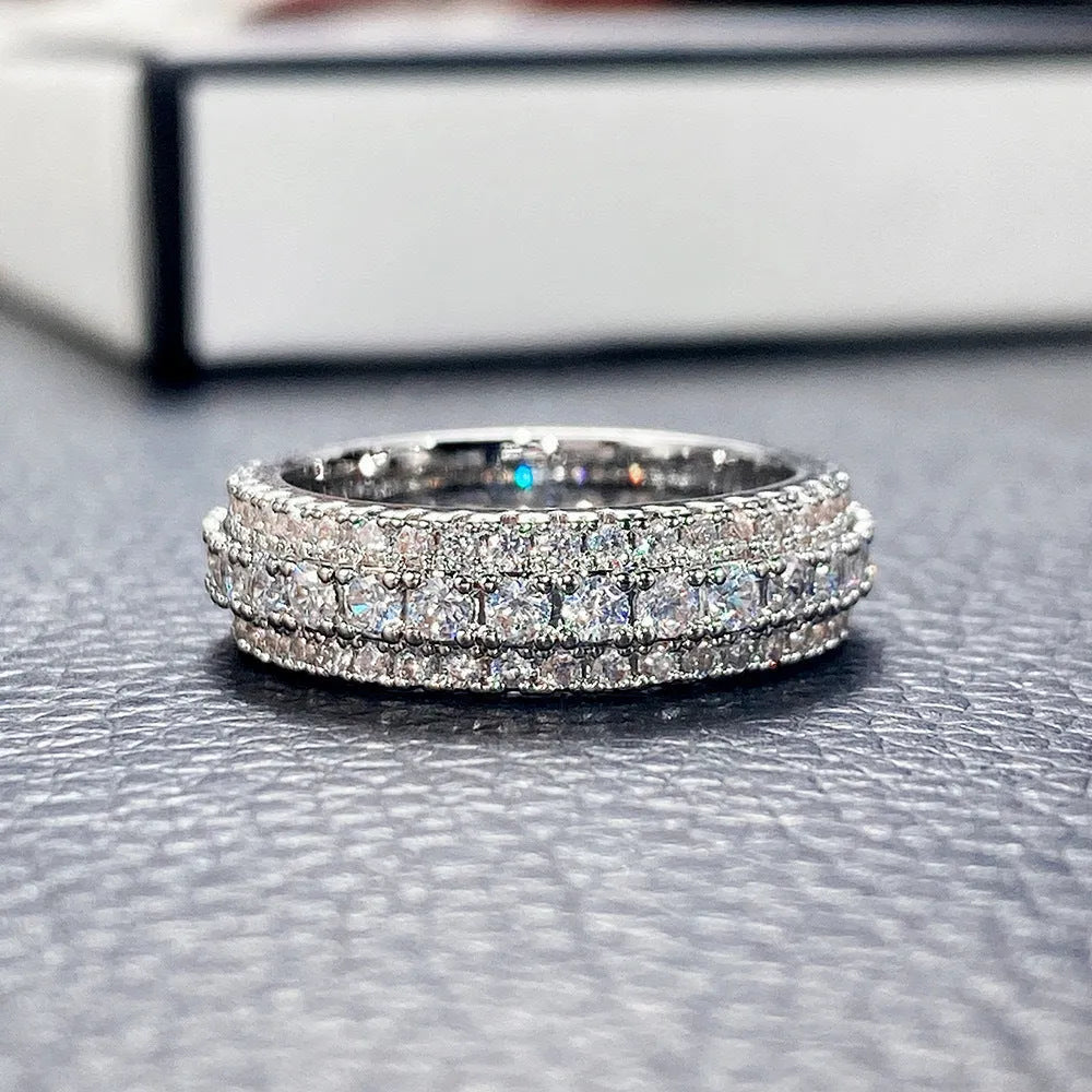 A geometric triangle ring with a zircon inlay, shown in a choice of platinum, yellow gold, or white and black colour.