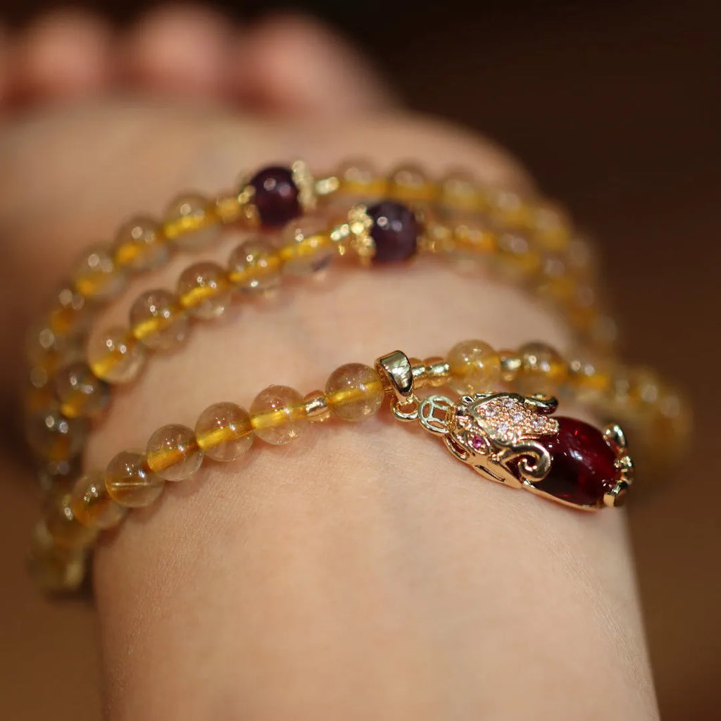 Natural Brazil gold rutilated quartz Chinese style bracelet with three gold rings and chopstick hanging detail.