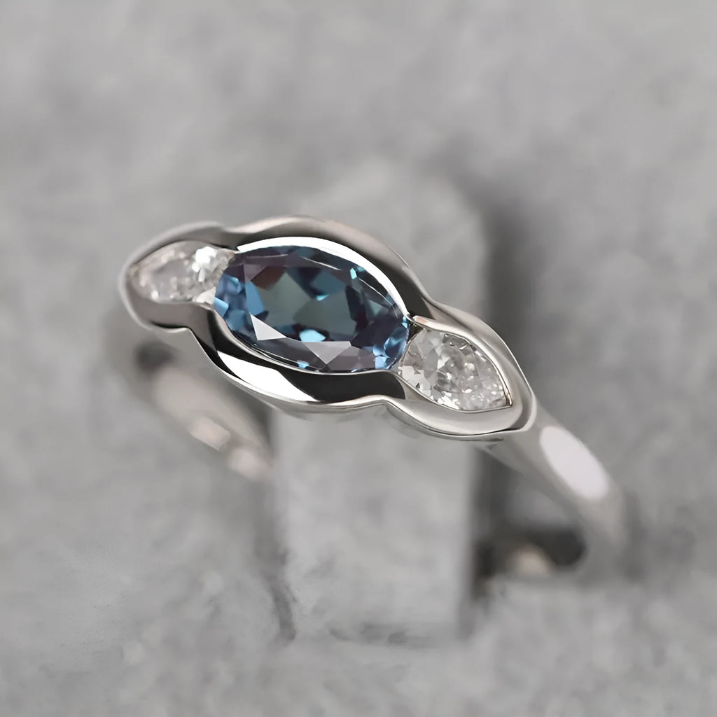 Geometric ellipse-shaped women's ring with zircon inlay in a white gold finish, shown on a hand.