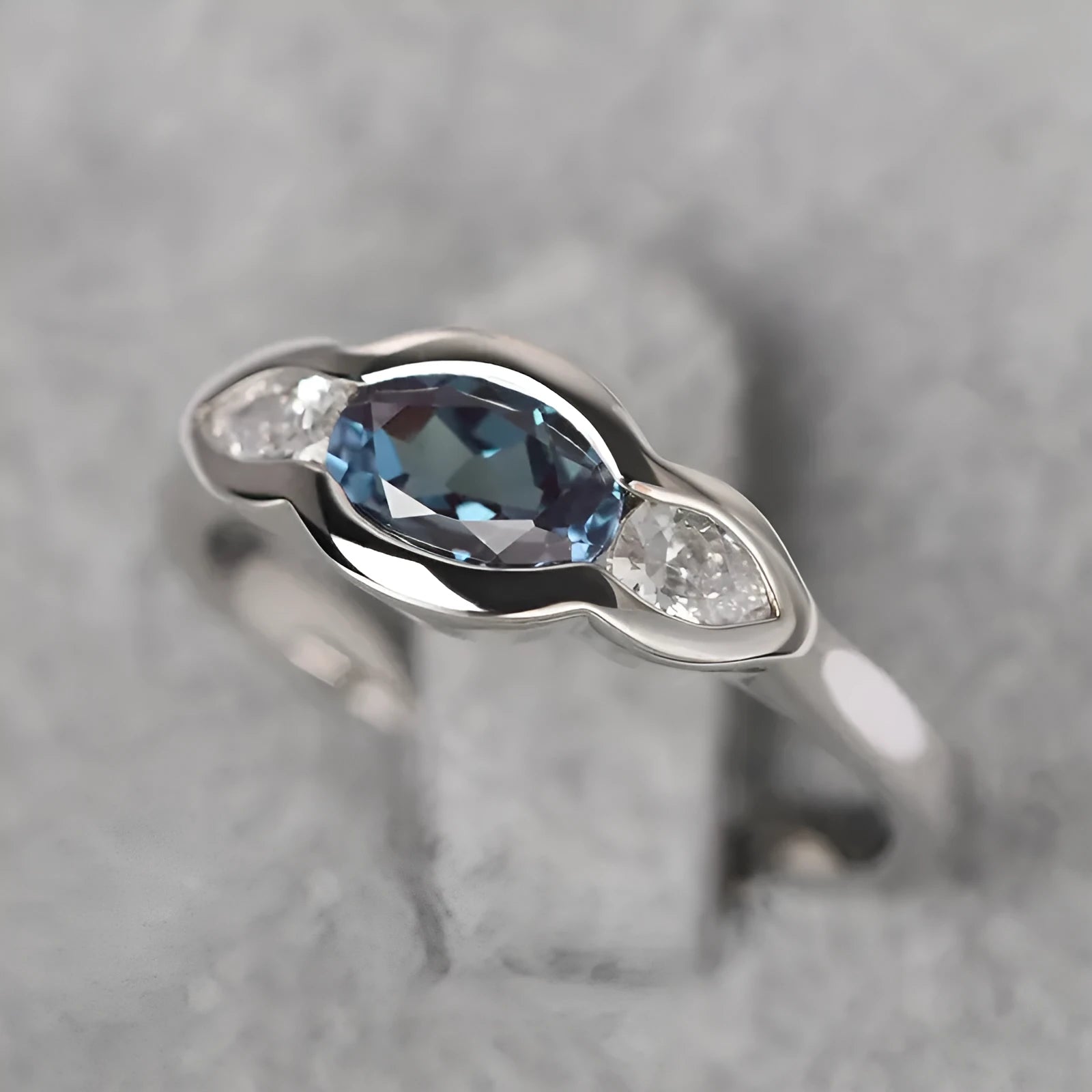 Geometric ellipse-shaped women's ring with zircon inlay in a white gold finish, shown on a hand.
