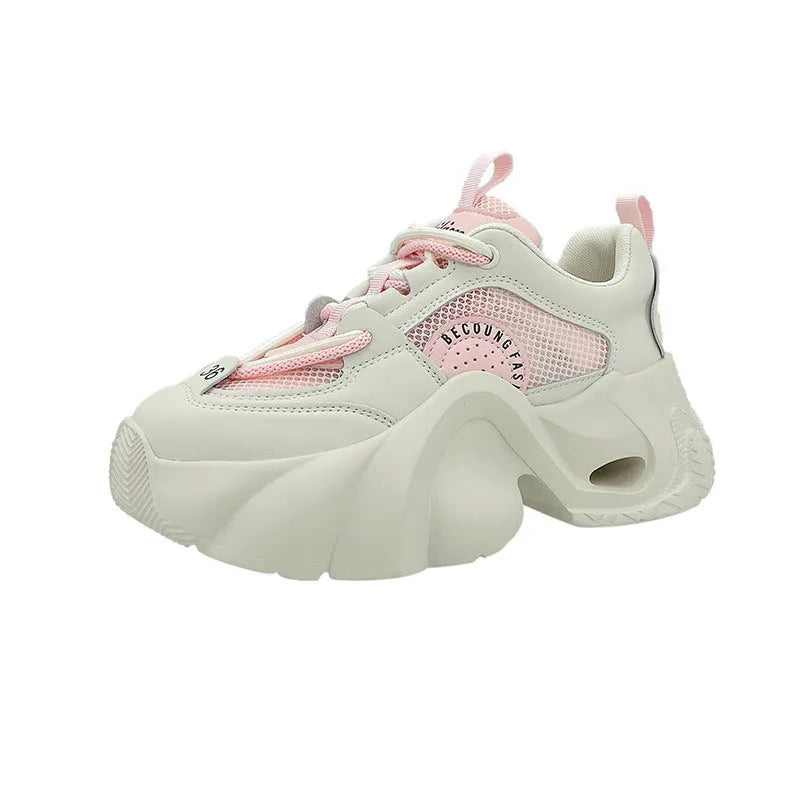 Women's pink platform sneakers with cross straps and a thick sole on a white background.