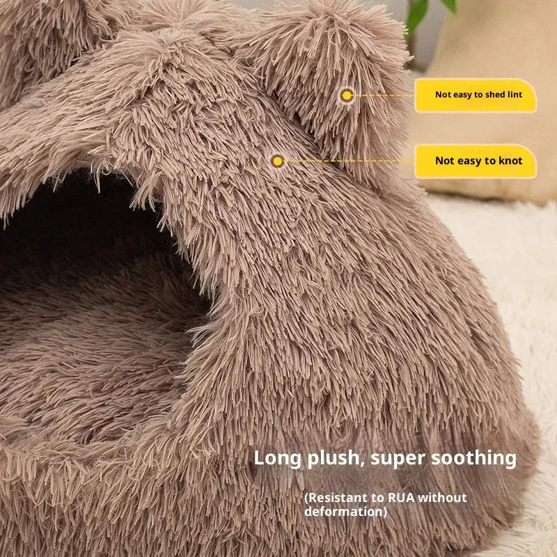 Large semi-closed flannel cat nest in dark gray on a floor, with soft plush interior visible