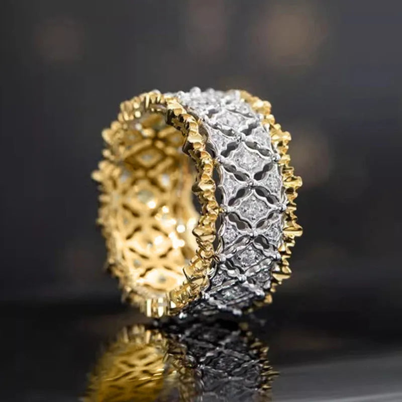 Geometric two-tone gold copper ring with round zircon accents on a solid background.