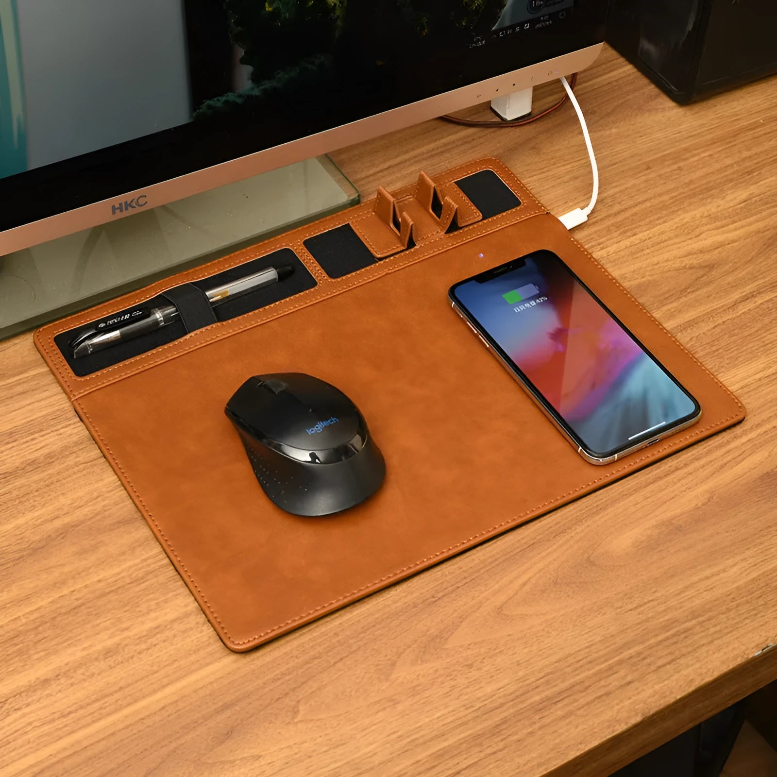 Pink wireless charging mouse pad with integrated mobile phone holder on a wooden desk