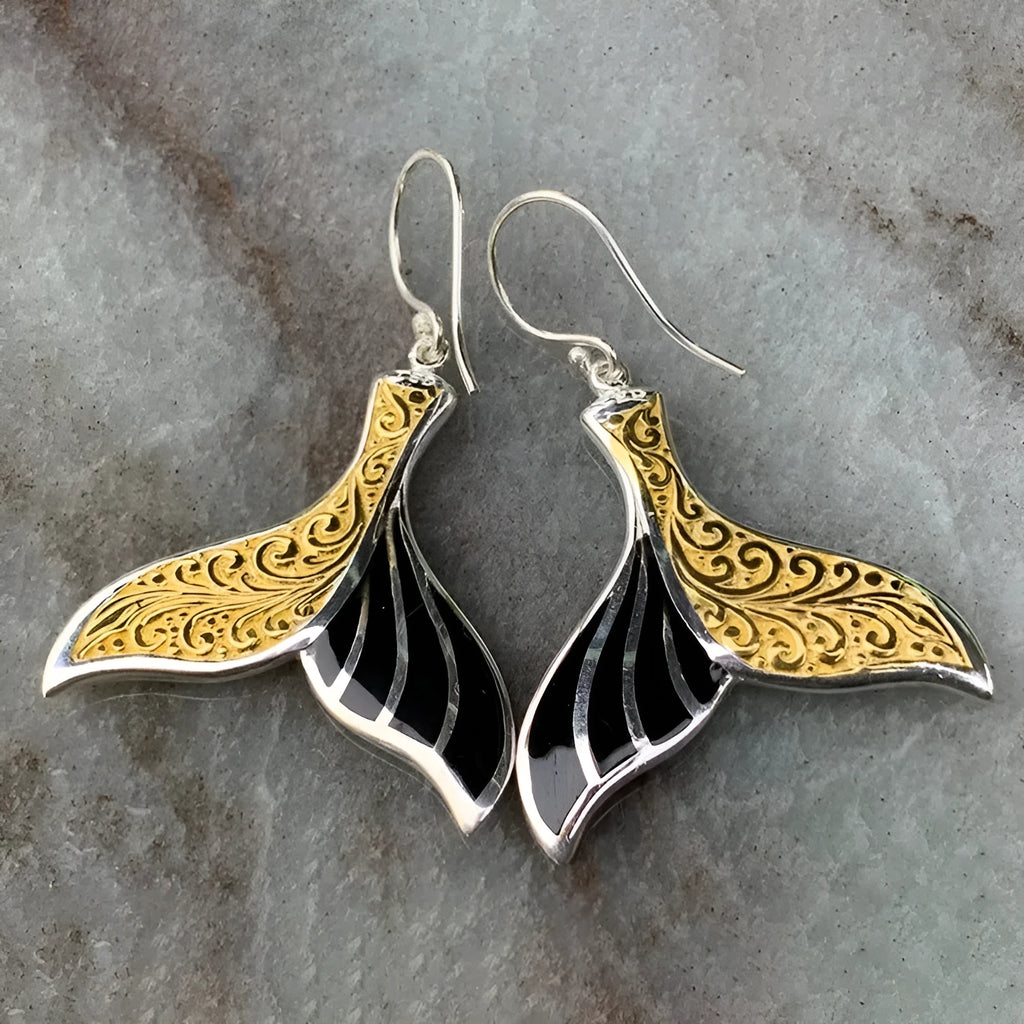 A pair of women's retro-style fishtail earrings with a whale decoration in white gold colour.