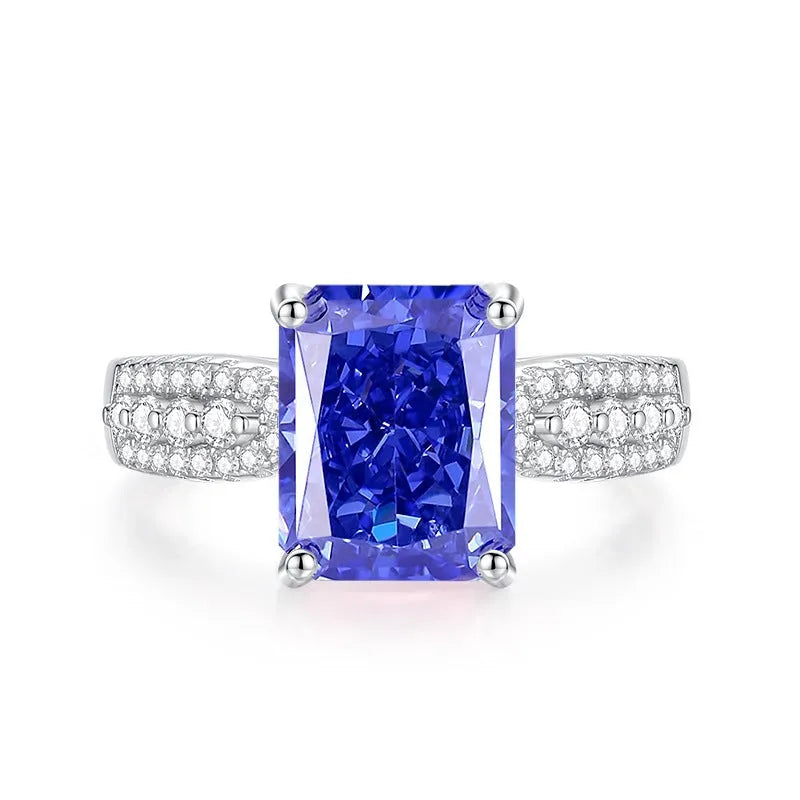 Close-up of a sterling silver heart-shaped ring with a floral-cut blue zircon stone.
