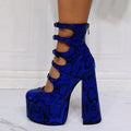 Black patent leather women's platform heel boots with a thick heel and a serpentine buckle strap.