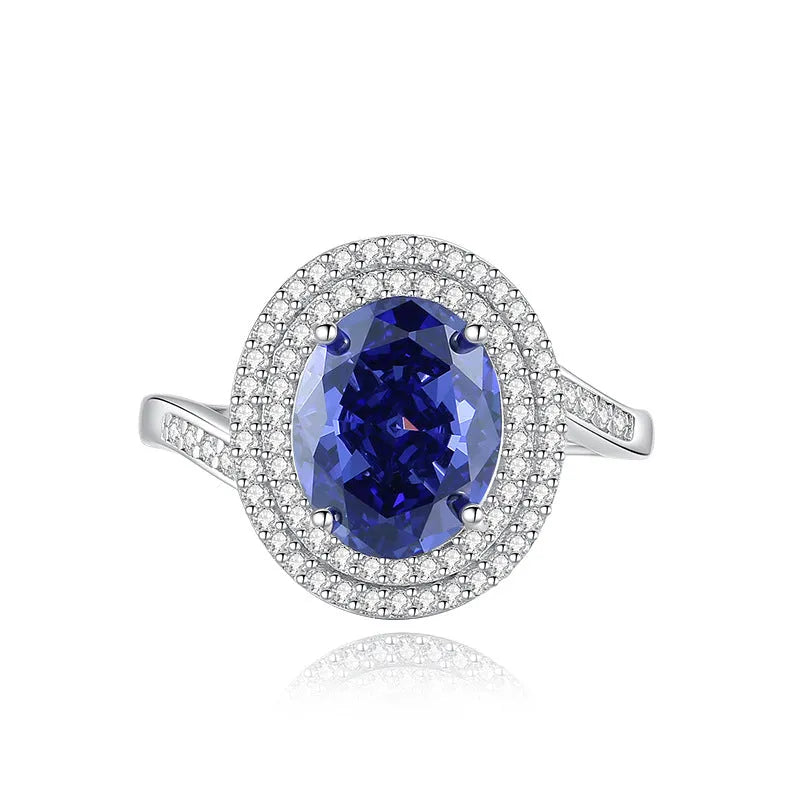 Close-up of a sterling silver heart-shaped ring with a floral-cut blue zircon stone.