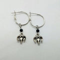 A pair of silver-coloured round alloy earrings featuring a Tibetan antelope design.