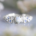 White electroplated alloy women's ring in a heart shape with floral and oceanic opal design details.