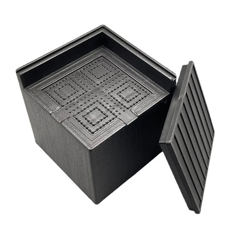 Four black plastic furniture risers or feet for beds and sofas