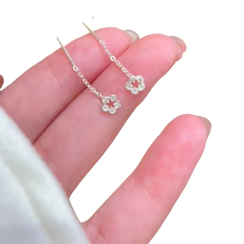 Silver colour hollow flower hanging earrings with petal design on female model