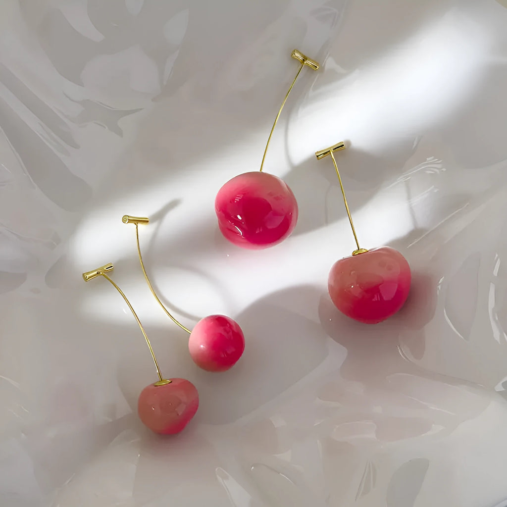 A pair of acrylic peach-shaped earrings with copper posts, shown in small and large size options.