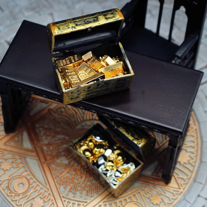Miniature alloy treasure chest doll house ornament with gold coin and bar design.