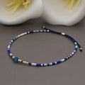 Handmade colourful beaded bracelet with semi-precious stone and glass charms on a wrist.