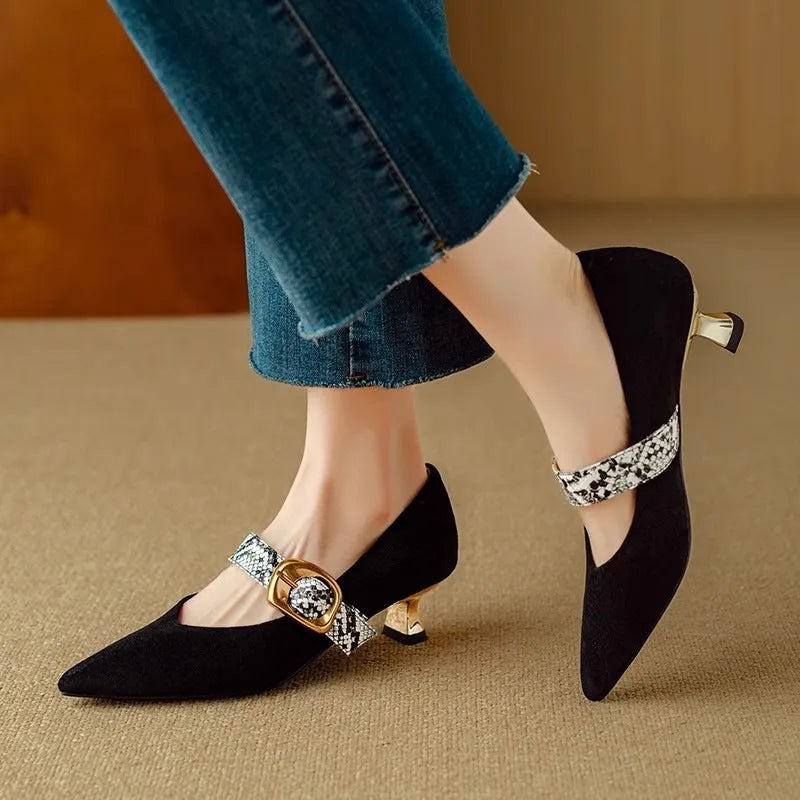 Women's black low-cut pointed stiletto heels with a silver buckle fastening on the ankle strap.
