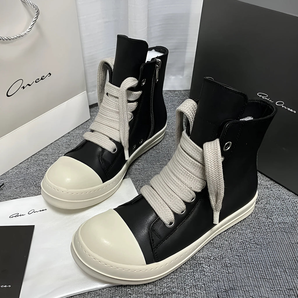Black high-top leather sneakers with side zipper and round toe on a white background