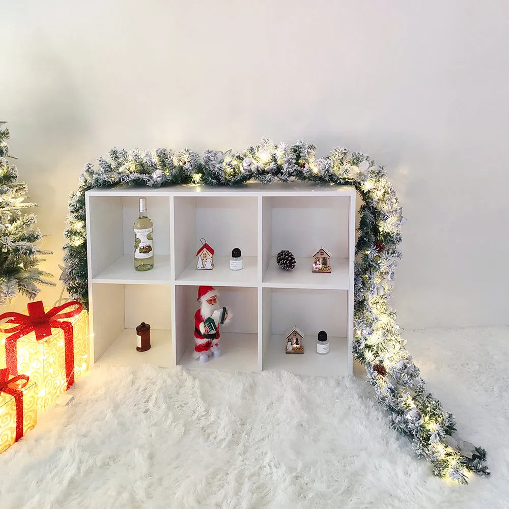 A long, flocked golden rattan Christmas garland draped in a swag on a mantelpiece.