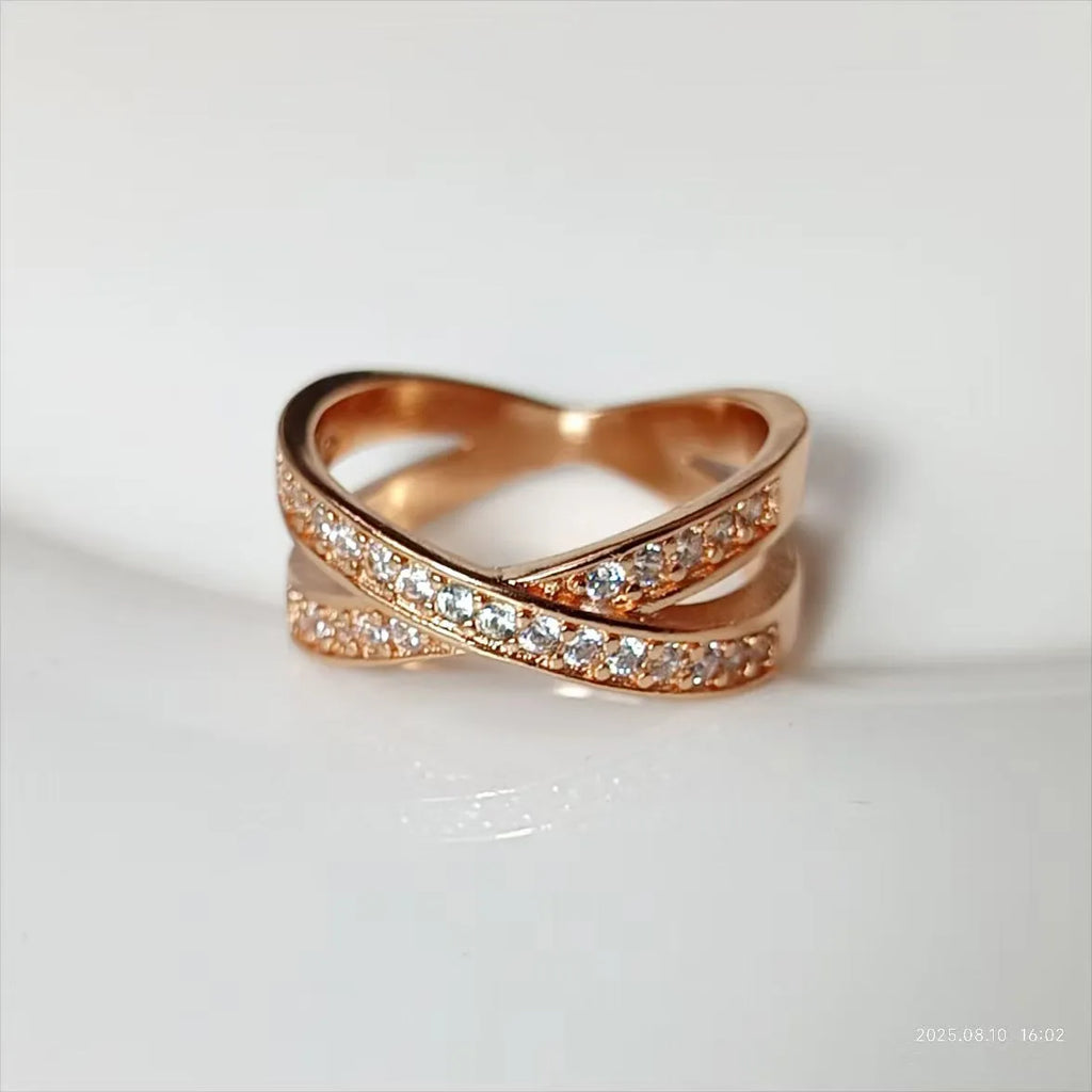 Silver and rose gold metal cross ring with micro-inlaid zircon, showing geometric and heart-shaped design.