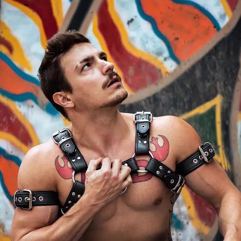 Black leather chest bondage strap with metal buckles on male torso