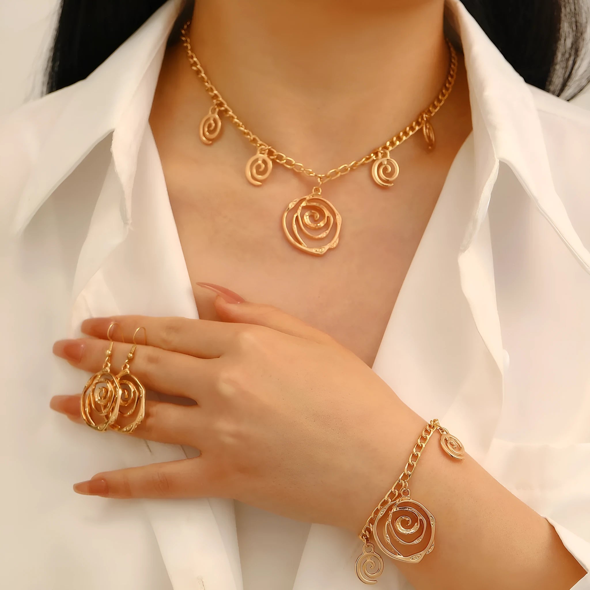 Spiral donut jewellery set showing necklace, bracelet, and earrings in geometric circle design with gold electroplated finish