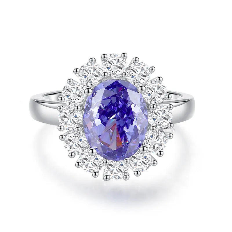 Close-up of a sterling silver heart-shaped ring with a floral-cut blue zircon stone.