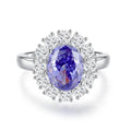 Close-up of a sterling silver heart-shaped ring with a floral-cut blue zircon stone.
