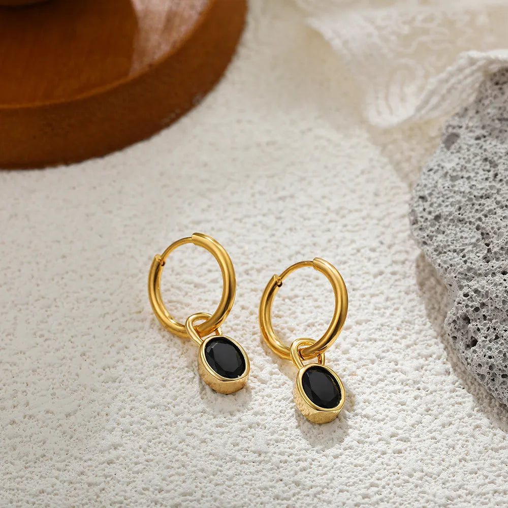 Close-up of a women's retro-style oval zircon drop earring in copper setting.