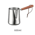 Stainless steel milk frothing pitcher with interior measurement scale and wooden handle