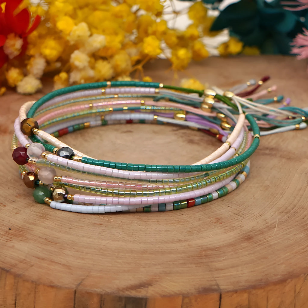 Handmade colourful beaded bracelet with semi-precious stone and glass charms on a wrist.